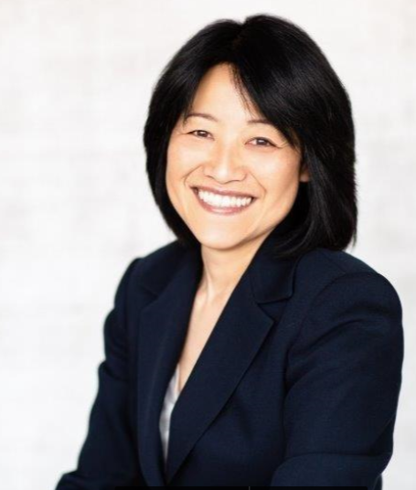 Smiling woman in a navy blazer against a light background